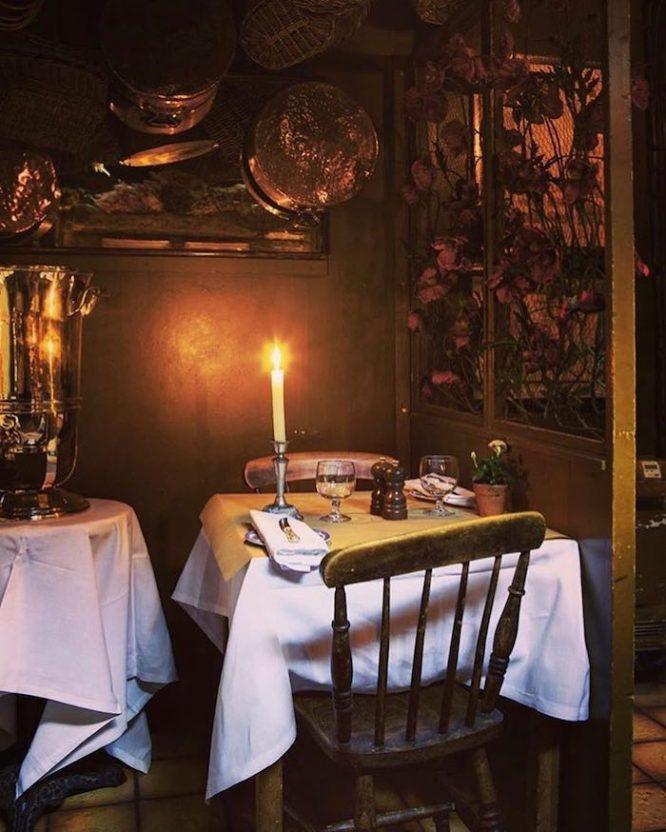 The interior of the romantic La Poule au Pot restaurant bathed in candlelight in London
