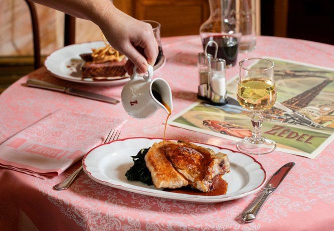 A lovely plate of food being covered in gravy at the French restaurant Brasserie Zedel in Soho